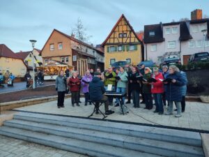 Gemischter Chor beim Auftritt auf dem Weihnachtsmarkt auf einer Außenbühne